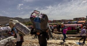 Trabajadores portan productos contrabandeados desde Bolivia.